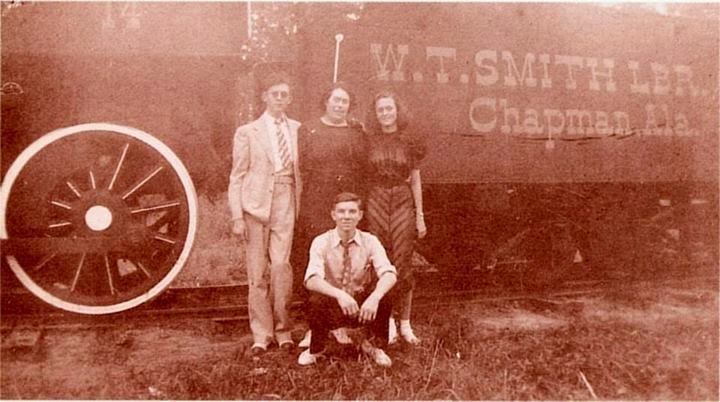 hank-williams-about-age-thirteen-joins-his-mother-lillie-his-sister-irene-and-his-cousin-j-c-mcneil-in-front-of-one-of-the-w-t-smith-log-trains